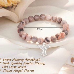 May include: A beaded bracelet featuring 8mm healing amethyst stones and a classic angel charm. The bracelet is 5.7 cm in diameter and is strung on a high-quality elastic string. Fits most wrists.
