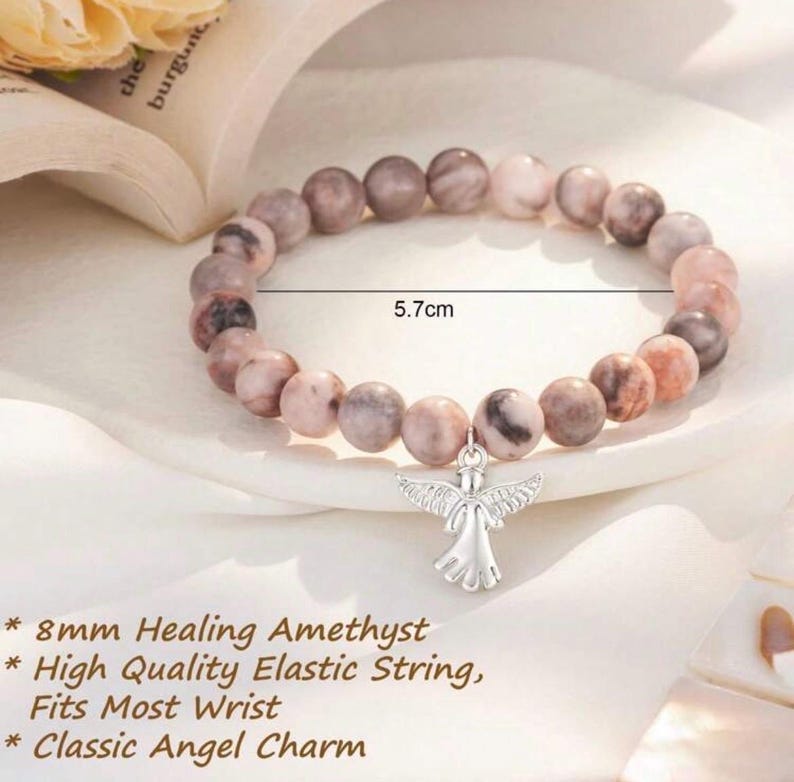 May include: A beaded bracelet featuring 8mm healing amethyst stones and a classic angel charm. The bracelet is 5.7 cm in diameter and is strung on a high-quality elastic string. Fits most wrists.