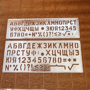 Novas réguas de estêncil em fontes de 16 e 20 mm com o alfabeto russo, números e símbolos para desenho e trabalho de design.
