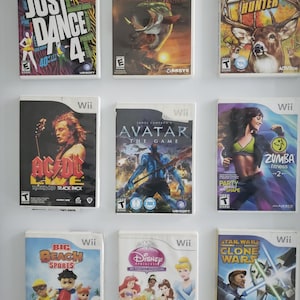 Puede incluir: Una colección de nueve estuches de videojuegos para la consola Nintendo Wii. Los estuches están dispuestos en tres filas de tres. Los juegos incluyen Just Dance 4, Hooked!, Monster Buck Hunter, AC/DC Live: Rock Band Track Pack, Avatar: The Game, Zumba Fitness 2, Big Beach Sports, Disney Princess: My Fairytale Adventure y Star Wars: Clone Wars - Lightsaber Duels.