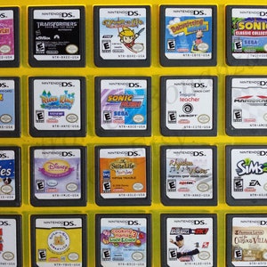 May include: A collection of 15 Nintendo DS game cartridges displayed in a yellow plastic case. The cartridges are arranged in three rows of five. The cartridges are all different colors and have different game titles on them. Some of the titles include "Jet Set & Style", "Transformers", "Down the Life", "Babysitting Mama", "Sonic Classic Collection", "Dogz", "River King", "Sonic Rush", "Imagine Teacher", "Mario Kart DS", "I Love Puppies", "Disney Musical Adventures", "The Suite Life", "Rhythm Heaven", "The Sims 2", "Cooking Mama 3", "MLB 2K7", "Professor Layton and the Curious Village".