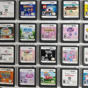 May include: A collection of 18 Nintendo DS game cartridges, including titles like 'Imagine Babyz', 'Plants vs. Zombies', 'FIFA Soccer 10', 'Dora Saves the Mermaids', and 'Big Brain Academy'.
