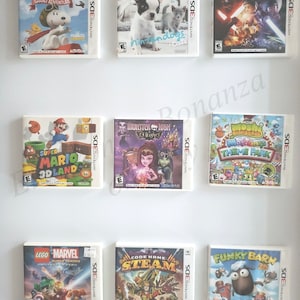 Puede incluir: Una colección de diez cartuchos de juego de Nintendo 3DS, que incluyen títulos como "Super Mario 3D Land", "Monster High 13 Wishes", "Moshi Monsters Theme Park", "LEGO Star Wars", "Snoopy's Grand Adventure", "Code Name: STEAM", "Funky Barn", "LEGO Marvel Super Heroes Universe of Peril", "French Bulldog Ninjindogs" y "Los Sims 3 Mascotas".