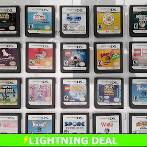 May include: A collection of 20 Nintendo DS game cartridges in clear plastic cases. The cartridges are arranged in four rows of five. The games include Lego Star Wars, Lego Harry Potter, Lego Batman, and more.
