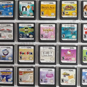 Könnte beinhalten: Eine Sammlung von Nintendo DS-Spielkassetten mit Titeln wie "Wappy Dog", "Brain Age", "Kirby Super Star Ultra" und "Mario Kart DS". Die Spiele werden in einem Raster angezeigt, das verschiedene Spielcover zeigt.