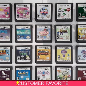 Puede incluir: Una colección de 20 cartuchos de juego de Nintendo DS que se muestran en una caja de plástico transparente. Los cartuchos están dispuestos en cuatro filas de cinco. Los cartuchos son de diferentes colores y tienen diferentes títulos. Los títulos incluyen "My Boyfriend", "Cooking Mama", "Hannah Montana", "That's So Raven", "Mario Kart DS", "Princess Frog", "Fossil Fighters", "Baby Phat", "Club Penguin", "Baby Pals", "Great Dinosaur Rescue" y "Nintendogs".