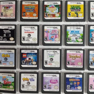 May include: A collection of 18 Nintendo DS game cartridges, including titles like Hello Kitty Party, Plants vs. Zombies, and Dora the Explorer. The cartridges are arranged in a grid pattern on a black surface.
