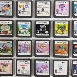 May include: A collection of 18 Nintendo DS game cartridges, displayed in a clear plastic case. The cartridges feature a variety of popular games, including Cooking Mama, Catz Clan, Imagine Fashion Designer, Plants vs Zombies, and Dora the Explorer.