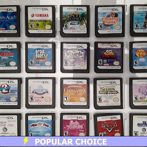 May include: A collection of 20 Nintendo DS game cartridges displayed in a clear plastic case. The cartridges are arranged in four rows of five. The cartridges are all different colors and have different titles, including Brain Age, Cooking Mama, and Shrek.