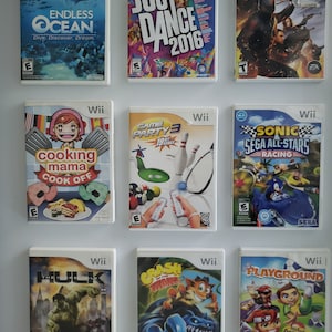 Puede incluir: Una colección de nueve estuches de juegos de video para la consola Nintendo Wii. Los estuches son blancos con imágenes y texto coloridos. Los juegos incluyen Endless Ocean, Just Dance 2016, G.I. Joe: The Rise of Cobra, Cooking Mama: Cook Off, Game Party 3, Sonic Sega All-Stars Racing, The Incredible Hulk, Crash: Mind Over Mutant y Playground.