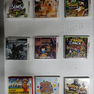 Puede incluir: Una colección de nueve cartuchos de videojuegos de Nintendo 3DS, que incluyen Los Sims 3 Mascotas, Golden Retriever & Cats, Rabbids Viaje en el Tiempo 3D, Ghost Recon Shadow Wars, Adventure Time: ¡No lo sé!, El Pack de Basura, Super Mario Maker 3DS, Bust-A-Move Universe y Driver Renegade.