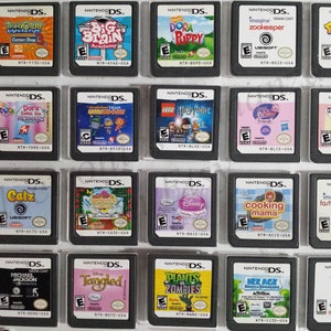 May include: A collection of 18 Nintendo DS game cartridges, including titles like "Dora Saves the Mermaids", "Big Brain Academy", "Zookeeper", "Catz", "Tangled", and "Plants vs. Zombies".