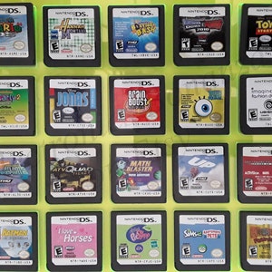 May include: A collection of Nintendo DS game cartridges displayed on a yellow background. Titles include "Super Mario", "Hannah Montana", "Brain Boost", "Toy Story 3", "iCarly 2", "Jonas", "Imagine Fashion Designer", and others.
