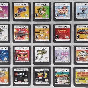 May include: A collection of 18 Nintendo DS game cartridges, including titles like "Cooking Mama", "Wall-E", "Brain Age 2", "Lego Battles: Ninjago", "Avatar: The Last Airbender", and "Toy Story 3".