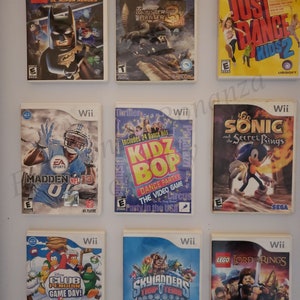 May include: A collection of nine Nintendo Wii video game cartridges. The games include Lego Batman 2, Monster Hunter 3, Just Dance Kids 2, Madden NFL 13, Kidz Bop Dance Party, Club Penguin Game Day, Skylanders Trap Team, Lego Lord of the Rings, and Sonic and the Secret Rings.