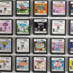 May include: A collection of 20 Nintendo DS game cartridges, displayed in a clear plastic case. The cartridges are arranged in four rows of five, and each cartridge features a different game title and cover art. Some of the games include Dora the Explorer, Imagine Babyz, and Cooking Mama.
