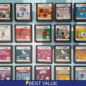 Pode incluir: Uma coleção de 18 cartuchos de jogo Nintendo DS, exibidos em uma caixa de plástico transparente. Os cartuchos estão dispostos em três filas de seis, com cada cartucho apresentando um título de jogo e uma arte de capa diferentes. Alguns dos jogos incluem "WordJong", "Imagine Babyz", "Mario Kart DS", "Animal Crossing: Wild World", "MySims Party" e "The New York Times Crossword".