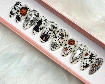 Könnte beinhalten: Set mit zehn weißen Halloween-Press-on-Nägeln mit verschiedenen Designs, darunter Geister, Kürbisse, Fledermäuse und Spinnen.