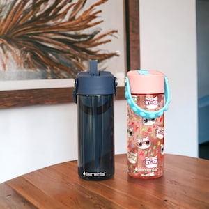 May include: Two blue and pink water bottles with a cat design and the word "elemental" on the bottom.