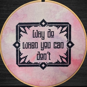 Könnte beinhalten: Ein rosa-violettes Aquarell-Kreuzstichmuster mit dem Text "Why do when you can don't" in einem schwarzen Rahmen. Das Muster ist auf 18ct Aida-Stoff gestickt.