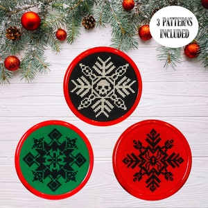 May include: Three round, red-framed ornaments with black and white snowflake designs. The ornaments are on a white wood background. The text "3 PATTERNS INCLUDED" is in the top right corner of the image.