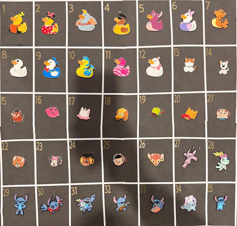 May include: A collection of 35 colorful rubber charms, including ducks, cartoon characters, and other whimsical designs. The charms are arranged in a grid on a dark background, showcasing a variety of shapes and colors.
