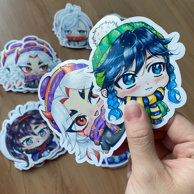 May include: Five colorful cartoon character stickers with winter clothing. The stickers feature characters with blue, white, and black hair wearing hats, scarves, and sweaters.