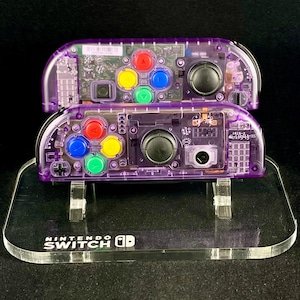Joy-cons de Nintendo en morado atómico con botones de arcoíris