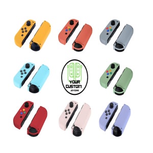 May include: A collection of colorful Joy-Con controllers in various shades, including yellow, orange, gray, light blue, green, red, pink, and purple. Each controller has a different button color scheme. The image also features a logo that says "YOUR CUSTOM JOYCONS."