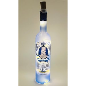 May include: A blue glass bottle with a cork stopper and a white LED light inside. The bottle has a label with a portrait of a man in a blue and gold uniform and the text "Hetman Vodka".