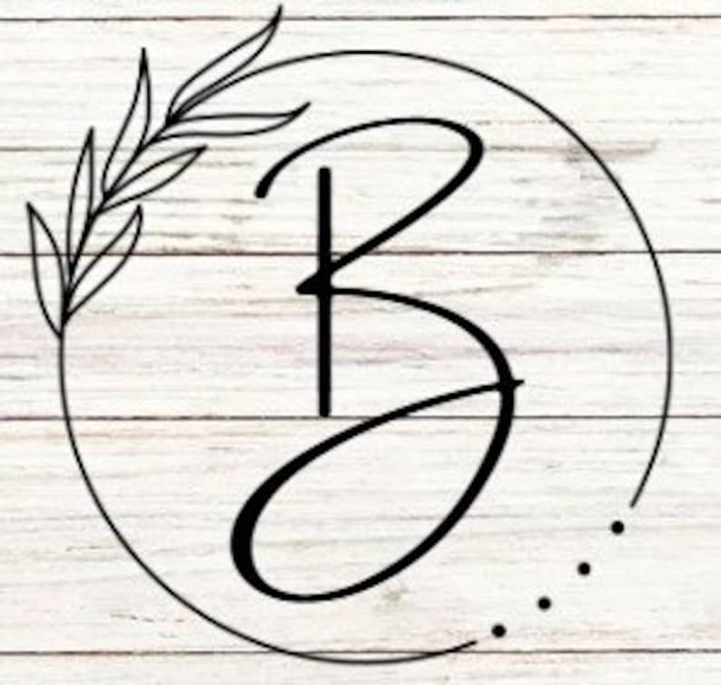 May include: A black and white illustration of the letter "B" in a circle with a leafy branch on the left side. The background is a white woodgrain pattern.