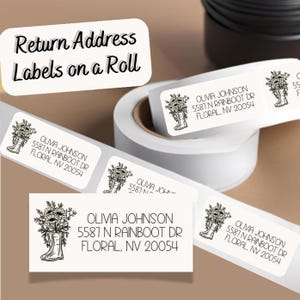May include: A roll of white return address labels with a black and white floral design featuring a boot. The labels have the text "OLIVIA JOHNSON 5587 N RAINBOOT DR FLORAL, NV 20054" printed on them.
