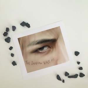 May include: A close-up of a person's eye with the text "The Shadow Like Me" written on the image.