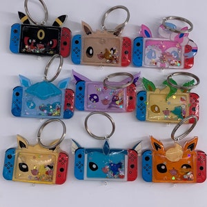 anime poke switch eeveelution shaker keychains, eevee, umbreon, leafeon, sylveon, glaceon, espeon, vaporeon, jolteon, flareon
