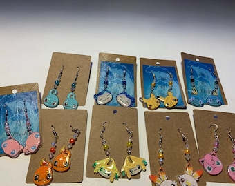 poke anima dangle resin earrings, snorlax, scorbunny, charmander, pikachu, jirachi, jigglypuff, mew, squirtle and sobble