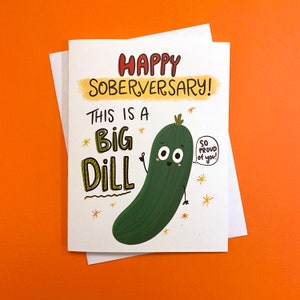 Pu&ograve; includere: Un biglietto bianco con un cartone animato di un cetriolo verde. Il biglietto dice "Happy Soberversary! This is a Big Dill. So proud of you!"