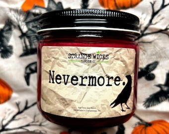 May include: A red candle jar with a black lid and a white label that says "STRANGE WICKS CANDLE CO" and "Nevermore."  The label also includes a black raven illustration and the text "Boz Para-Soy Blend" and "Handmade in Chattanooga, TN."