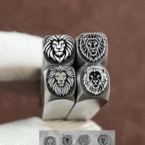 Pode incluir: Quatro carimbos de metal com desenhos de cabeça de leão. Cada carimbo apresenta um rosto de leão detalhado com uma juba. Os carimbos estão dispostos em um quadrado, com uma fileira menor de desenhos de cabeça de leão na parte inferior.