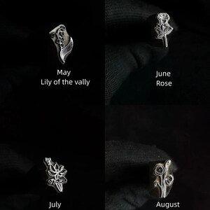 Pu&ograve; includere: Quattro timbri metallici con disegni floreali che rappresentano i mesi di maggio, giugno, luglio e agosto. I timbri sono disposti in una griglia su uno sfondo nero. I fiori sono mughetto, rosa, loto e papavero.