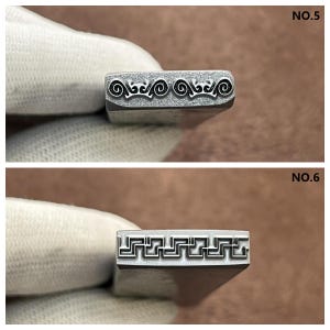 May include: Two metal stamps with different designs. The top stamp has a repeating pattern of swirls and the bottom stamp has a repeating pattern of squares.