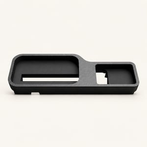 May include: A matte black desk organizer tray featuring a textured finish with two distinct recessed compartments. The larger rectangular section includes a horizontal slot, while the smaller square section is positioned to the right side.