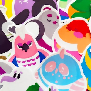 May include: A collection of colorful stickers featuring various cartoon birds. The stickers are printed on white paper and have a glossy finish. The birds are depicted in various poses and expressions, including a bird with a crown, a bird with a heart, and a bird with a surprised expression.