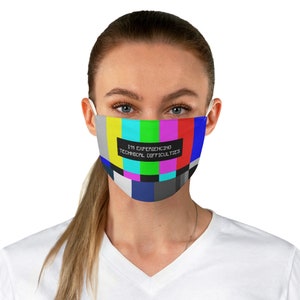 May include: A white face mask with a colorful television test pattern and the text "I'm experiencing technical difficulties".