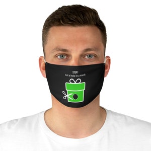 May include: Black face mask with a green gift box graphic and the text "STEP 1 Cut a hole in a mask". The graphic includes scissors cutting a hole in the gift box. The mask is worn by a person.