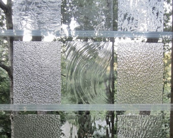May include: Nine different types of textured glass panels, each with a unique pattern. The panels are arranged in a grid pattern, with three rows and three columns.