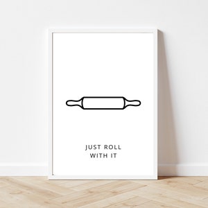 May include: A white framed print with a black line drawing of a rolling pin and the text "JUST ROLL WITH IT".