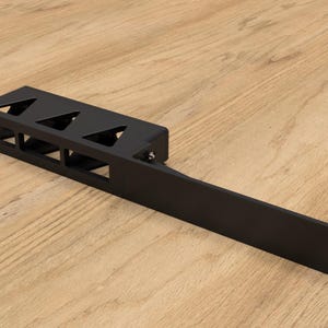 May include: Black metal rack with five slots for holding items. The rack has a long, flat base and a raised section with triangular cutouts.