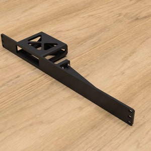 Puede incluir: Soporte de metal negro con un recorte rectangular y una caja rectangular más pequeña con un diseño geométrico. El soporte mide aproximadamente 45 cm de largo.