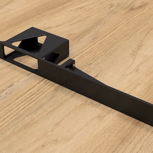 May include: Black metal bracket with a rectangular opening and a smaller, triangular opening. The bracket is designed to mount a device or object.