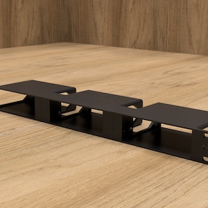 Può includere: Scaffale in metallo nero con tre scomparti, progettato per riporre ed esporre piccoli oggetti. Lo scaffale è realizzato in metallo robusto e presenta un design elegante e moderno.